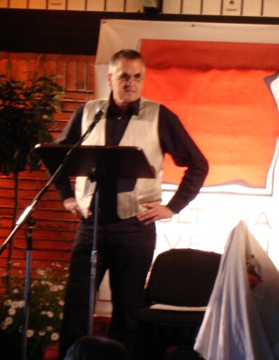 Buchautor Manfred Fock bei einer literarischen Live-Lesung an einem Rednerpult in Schleswig.